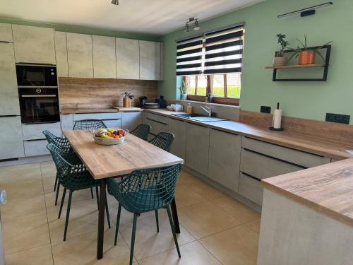 a kitchen with a wooden table and chairs in it at Gîte Le 3 in Gesves