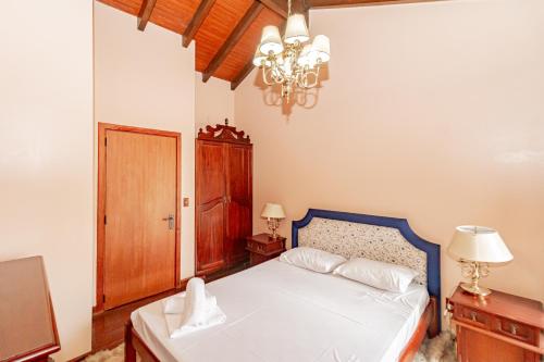 格拉玛多Duplex 3 Quartos Wish Serrano Resort的一间带床和吊灯的卧室