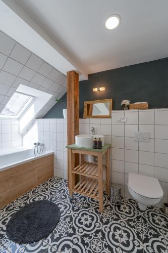 a bathroom with a sink and a toilet and a tub at Penzion Medové údolí in Čábuze