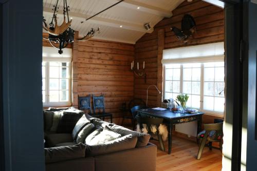 a living room with a couch and a table at Historic Hunting Lodge By Lake Øyangen in Hønefoss