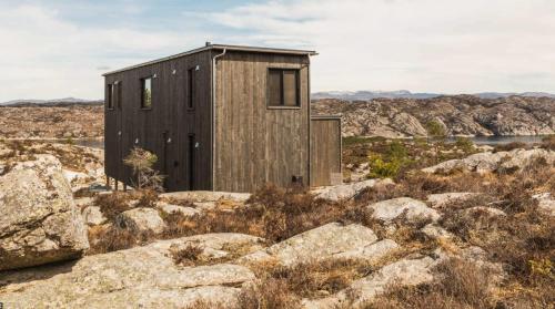 a small wooden building on top of some rocks at Architect-Designed Cabin Panoramic View in Ervik