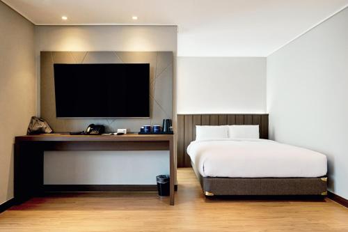 a bedroom with a bed and a flat screen tv at The Hotel Sokcho in Sokcho
