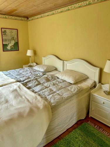 a bedroom with a large white bed with two pillows at 18Th Century House With Glass Porch In Småland in Söderåkra