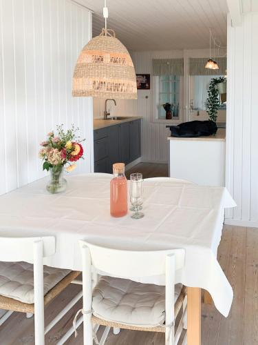 a white dining room with a white table and chairs at Beachfront House At Hølken Beach in Odder