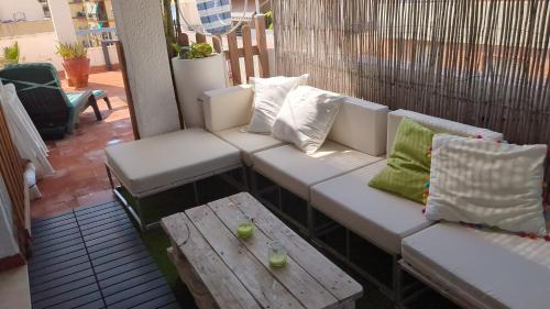 a white couch and a table on a balcony at Ático in Almuñécar