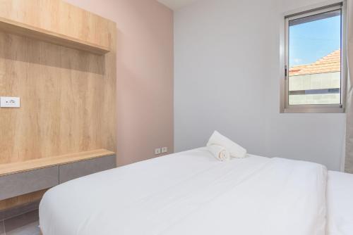 a bedroom with a white bed and a window at Grey - Elegant Apartments in Awkar in Dbayeh