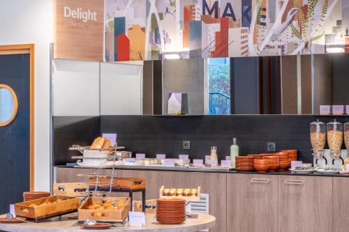 a restaurant with a counter with food on it at Spark by Hilton Lyon Park Saone in Lyon