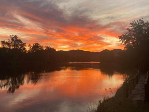a sunset over a river with the sun setting at Edge of the Crater in Venterskroon