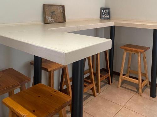 a kitchen counter with a table and some stools at Edge of the Crater in Venterskroon