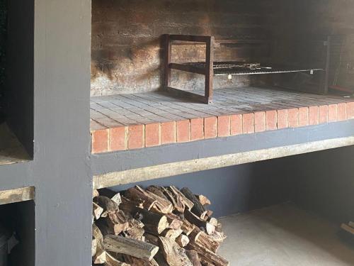 a pile of fire wood next to a fireplace at Edge of the Crater in Venterskroon