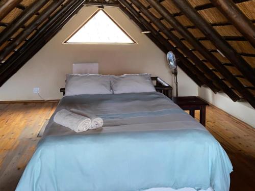a large bed in a room with a window at Edge of the Crater in Venterskroon