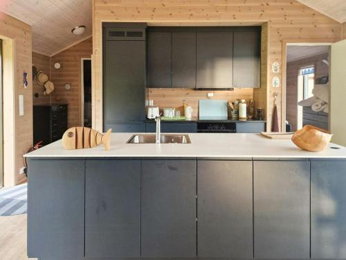 a kitchen with gray cabinets and a white counter top at Seaside Cabin With Panoramic Views In Alvundfjord in Ålvundeid
