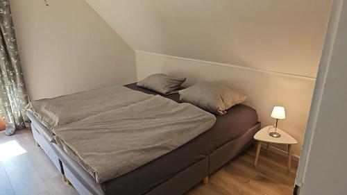 a bed in a small room with a side table at Ferienwohnung Am Pfaffenberg in Weilmünster