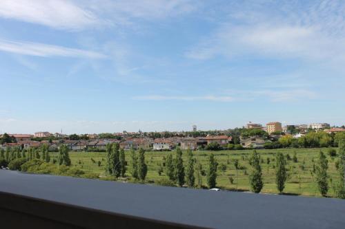 Una vista de un campo y árboles desde la ventana de un tren. en NEWTON30 - Luminoso bilocale in zona servita, en Rávena
