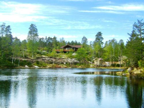 a house on a hill next to a lake at 8 person holiday home in BJELLAND-By Traum in Bjelland