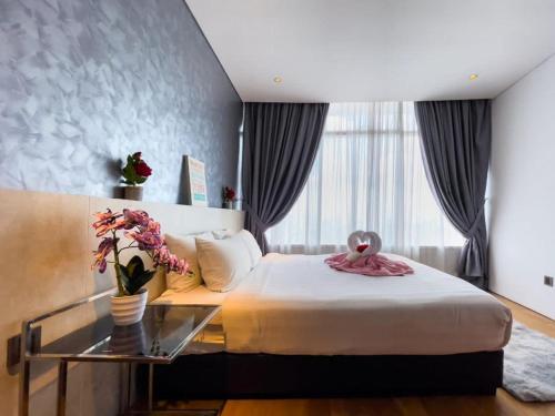 a bedroom with a large bed and a glass table at The Luxury Penthouse KLCC in Kuala Lumpur