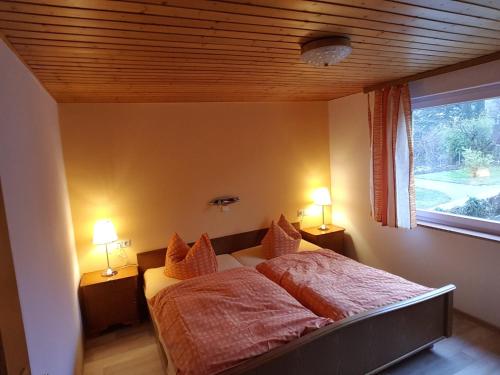 a bedroom with a bed and a window with two lamps at Ferienwohnung in Bischoffingen in Bischoffingen