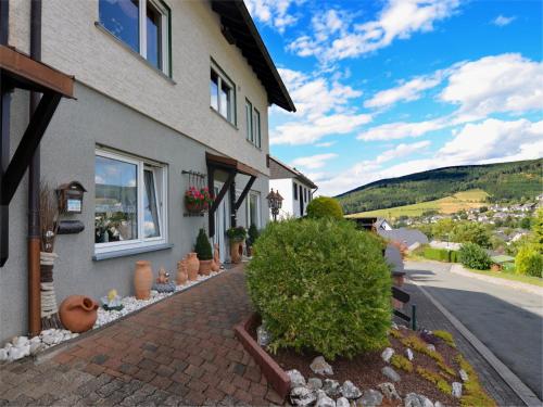 a house with a brick walkway next to a street at Modern Escape in Niedersfeld in Winterberg