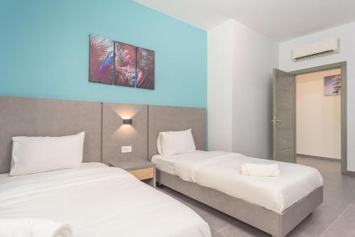 a hotel room with two beds and a blue light at Grey - Elegant Apartments in Awkar in Dbayeh