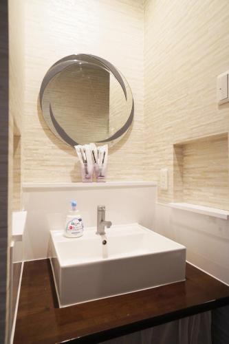 a bathroom with a white sink and a mirror at Nishiki-en in Osaka