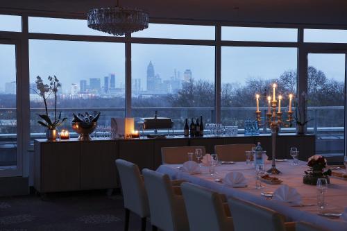 a dining room with a table and a view of the city at SOALTEE Hotel by Trip Inn Frankfurt Messe Tagungshotel in Frankfurt/Main