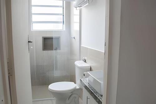 a white bathroom with a toilet and a shower at Apartamentos estilo loft pertinho da rota do vinho in São Roque