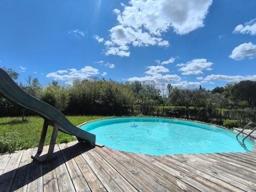 Gîte en Provence في كافايو: حمام سباحة مع منزلق بجوار سطح خشبي