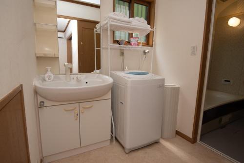 a bathroom with a sink and a toilet and a mirror at Sobahachi Stay in Nasushiobara