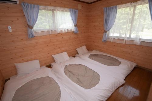 a bedroom with two beds in a room with windows at Sobahachi Stay in Nasushiobara