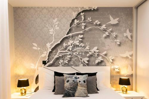 a bedroom with a white bed with birds on the wall at Lobos Dream Flat by Escape to Madeira in Câmara de Lobos