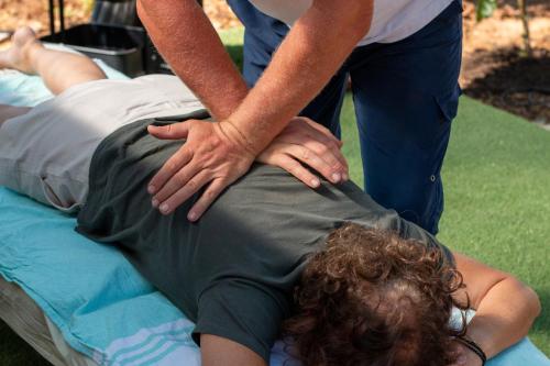 a man holding the back of a person on a bed at Casa Terapia in Loulé