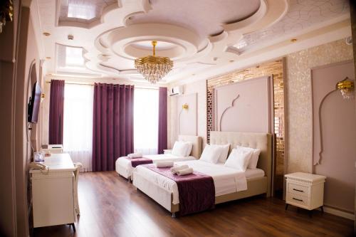 a bedroom with two beds and a chandelier at Hotel Dali Samarkand in Samarkand