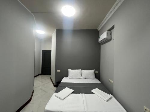 a small bedroom with a bed with white sheets at Dreem House in Yerevan