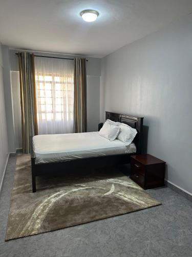 a bedroom with a large bed and a window at Ecostay 2bedroom Makasembo in Kisumu