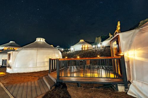 a couple of yurt tents with lights in the night at Blue Spot Resort in Yoliin Hural