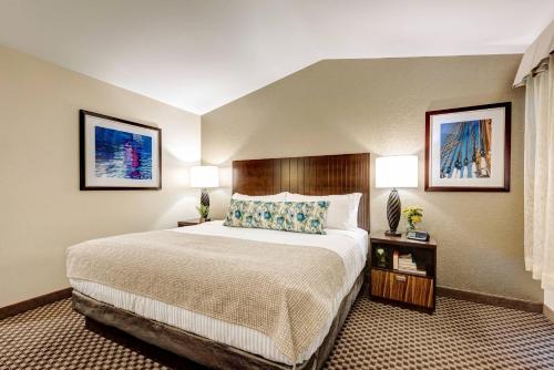 a hotel room with a bed and two lamps at Garrison Hotel & Suites Dover-Portsmouth, an Ascend Collection Hotel in Dover