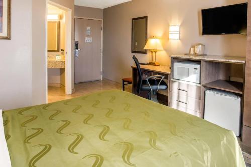 a small hotel room with a bed and a kitchen at Quality Inn Moriarty in Moriarty