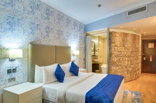a bedroom with a large bed with blue walls at Leola Boutique Hotel Ikeja - Lagos in Lagos
