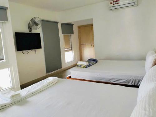 Khải Lộc Minh Hotel Hồ Chí Minh في مدينة هوشي منه: غرفة بسريرين وتلفزيون فيها