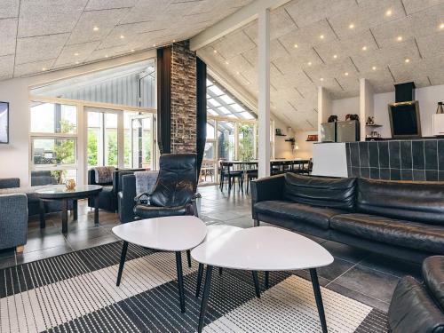 a living room with a couch and tables and chairs at 5 star holiday home in Brovst in Brovst