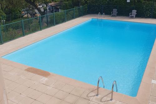 una grande piscina blu accanto a una recinzione di Detached house with 3 pools a Cogolin