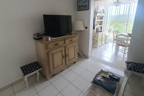 un soggiorno con una TV a schermo piatto su un mobile di Detached house with 3 pools a Cogolin