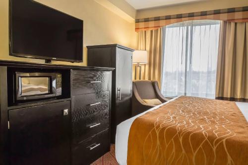 a hotel room with a bed and a flat screen tv at Comfort Inn & Suites LaGuardia Airport in Queens