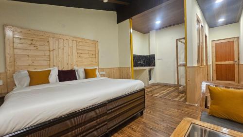a bedroom with a large bed with a wooden headboard at Himalayan Chill House - Dragon Chowk, Old Manali with Mountain View, Balcony and Kitchen Access in Manāli