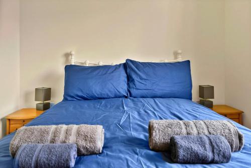 a blue bed with two pillows on top of it at Finest Retreats - Lavender Waye in Okehampton