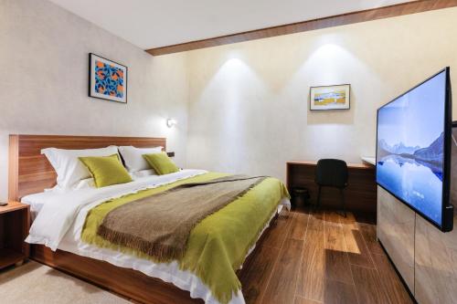 a bedroom with a bed and a flat screen tv at Songshan Lake Minshu Villa 