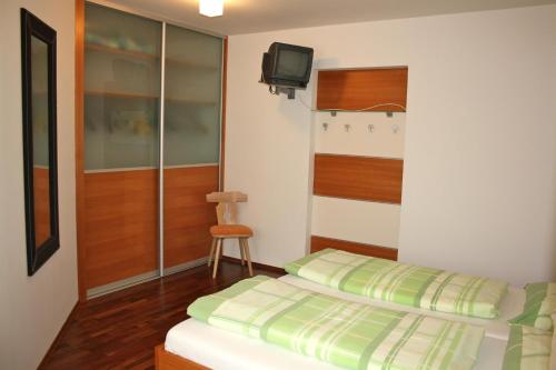 a bedroom with a bed and a tv on the wall at Haus Zisser in Sankt Jakob im Walde
