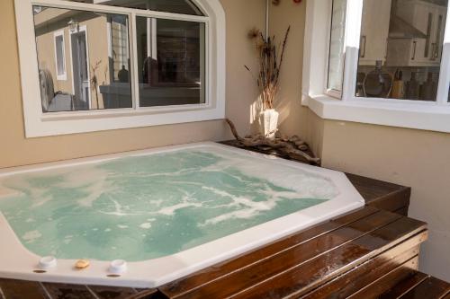 HornleeにあるGreenside Get Awayの窓のある部屋にある温水浴槽