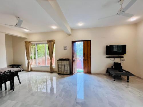 an empty living room with a television and a table at Krushnai Akshay Villa - Neral in Vangani