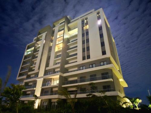 a tall white building at night at Elandor Suite East Minissy Moka in Moka